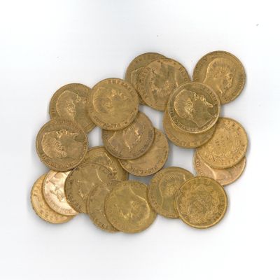 une pile de pièces d'or posée sur une surface blanche
