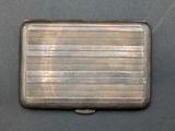 silver metal business card case sitting on top of a black surface