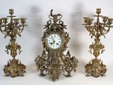 Trois horloges anciennes sont posées les unes à côté des autres sur une surface blanche