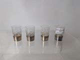 four glasses sitting on a table with labels on them