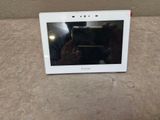 Quelqu'un prend une photo d'une tablette blanche posée sur une table