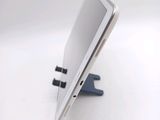 a tablet computer sitting on a stand on a white surface