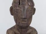 a wooden sculpture of a man with a broken head