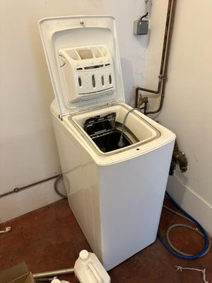 a washing machine that is sitting in the corner of a room