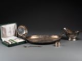 une assiette en argent avec une cuillère et un repose-cuillère posés sur une table