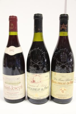 three bottles of wine are lined up on a white surface