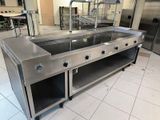 a large stainless steel kitchen with a sink and a counter