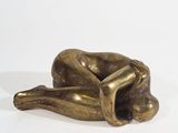a bronze sculpture of a dog laying down on its back