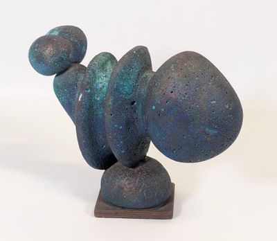 une sculpture composée de pierres bleues et vertes posées sur un socle en bois