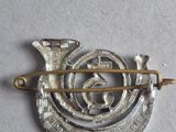 a silver and gold brooch with a bird on it