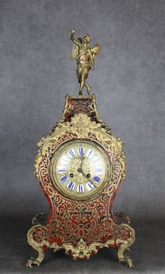 une horloge posée sur un socle, surmontée d'un oiseau