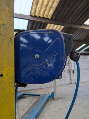 un tuyau bleu fixé sur le côté d'un poteau jaune