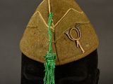 a hat with a green tassel on top of a mannequin head