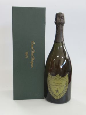 une bouteille de champagne posée à côté d'une boîte verte