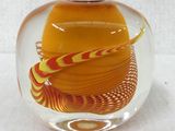 a glass vase with a yellow and red swirl inside of it