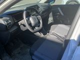 the interior of a car with the door open and the driver ' s seat down