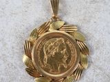 a close up of a gold coin on a gold chain