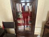 une armoire en bois avec une porte vitrée, devant laquelle se trouve une chaise