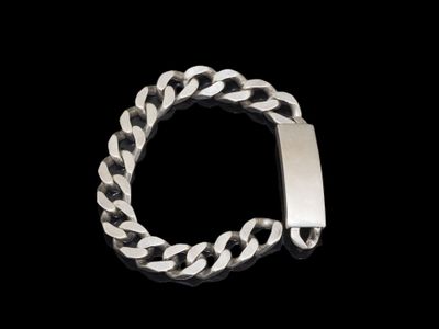 un gros plan d'un bracelet muni d'un fermoir en métal sur fond noir