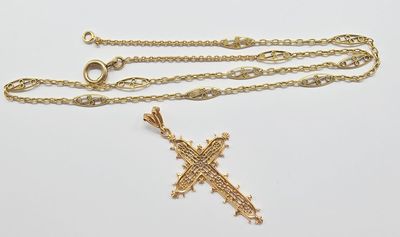 un gros plan d'une chaîne en or ornée d'une croix