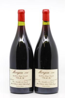 two bottles of red wine sitting next to each other on a white surface