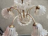 a chandelier that has five glass flowers on it