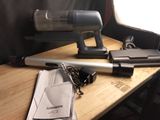 a gun on a table next to a cell phone and other items