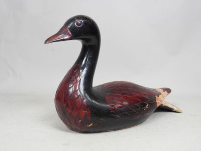 une image représentant une figurine de canard noir et rouge sur fond blanc