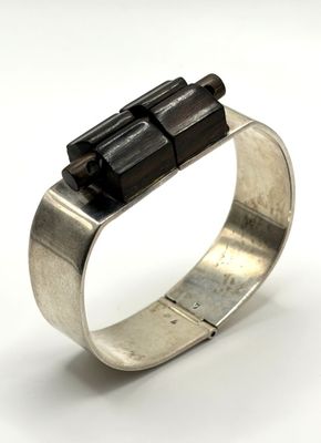silver ring with black stones on top of it on a white surface