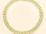 a close up of a gold chain bracelet on a white background