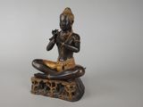 statue of a woman sitting on a rock playing a flute