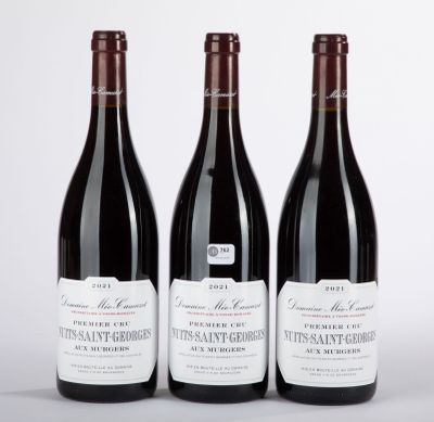 trois bouteilles de vin sont alignées sur une surface blanche