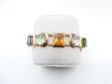 an image of a ring with multi colored stones on a white surface