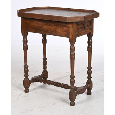 an old wooden table with turned legs and a wooden tray on top
