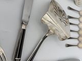 a lot of silverware on a table with spoons and forks