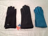 trois paires de gants en cuir noir posées sur un drap blanc