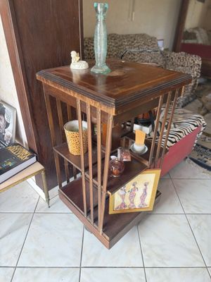 a small wooden table with a vase on top of it