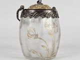 an antique silver and glass jar with a floral design on the lid