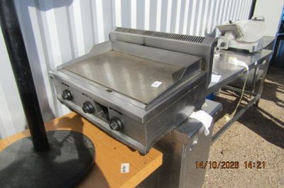 un barbecue posé sur une table devant un immeuble