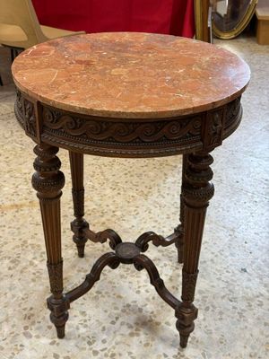 une petite table avec un plateau en marbre dans une pièce