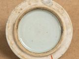 a small white plate with a brown rim on a brown surface
