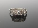 an art deco diamond ring with filigree shoulders