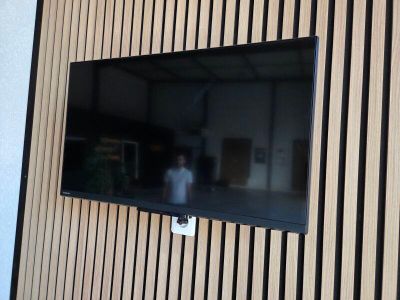 un téléviseur à écran plat fixé au mur d'une pièce