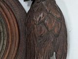 a wooden clock with an owl on it on a wall