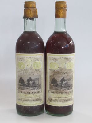 deux bouteilles de vin posées l'une à côté de l'autre sur une surface blanche