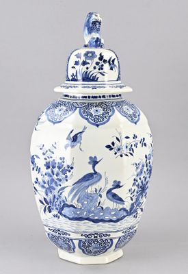 blue and white vase with a bird on top of it
