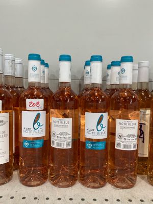 bottles of wine are lined up on a shelf in a store
