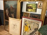 Il y a beaucoup d'œuvres d'art encadrées posées par terre dans cette pièce