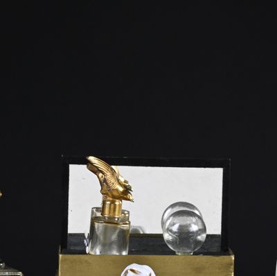 bottles of perfume on a table next to a clock and a mirror
