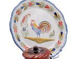 a small plate with a rooster on it on a stand